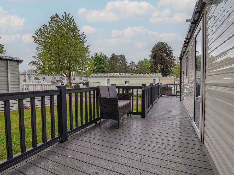 An outdoor area with a deck and chairs at Willerby Malton in Ruthin