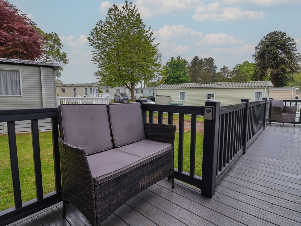 A sitting area with a chair on a deck at Willerby Malton in Ruthin
