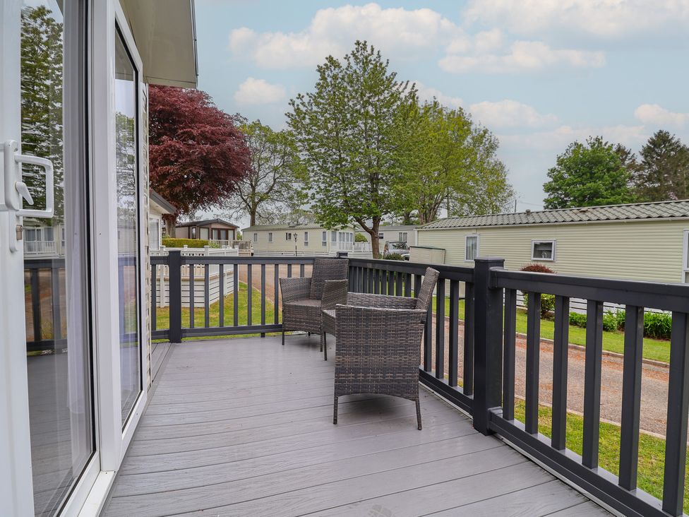 An outdoor area with chairs on a deck at Willerby Malton in Ruthin