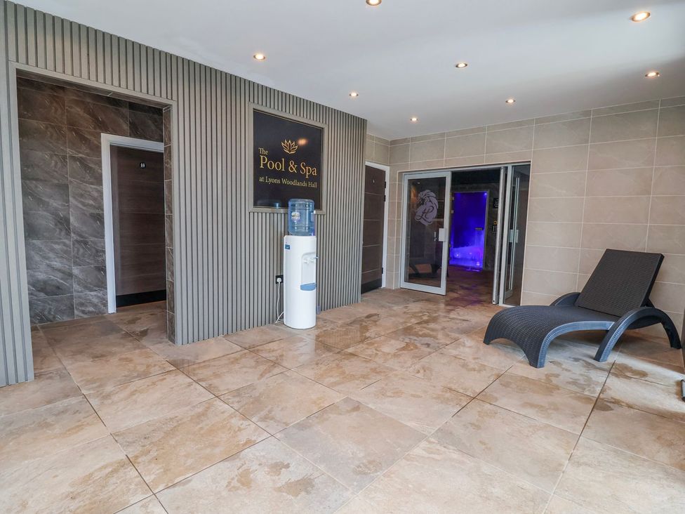 A spa area with a water dispenser and lounge chair at Lyons Woodlands Hall