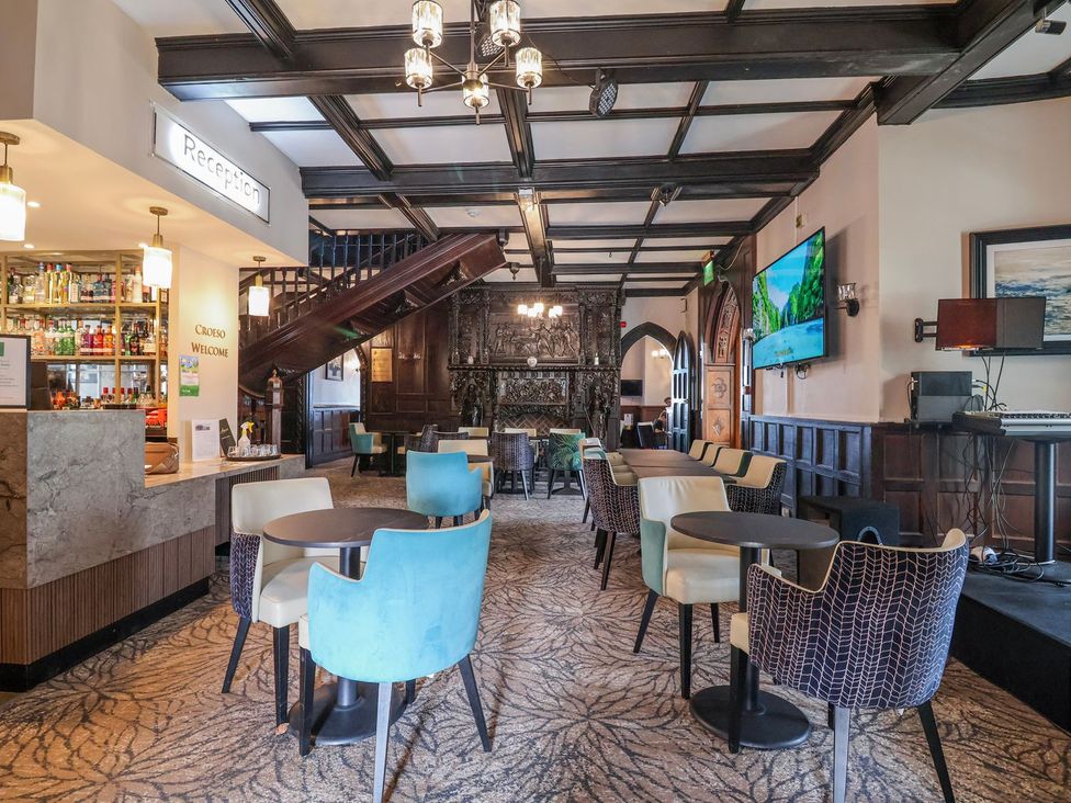 A lounge area with seating and a bar counter at Willerby Malton in Ruthin