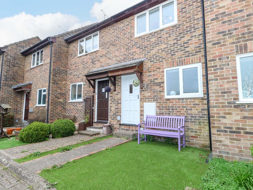 An outdoor area with a brick exterior and a purple bench at Amber House in Dorchester