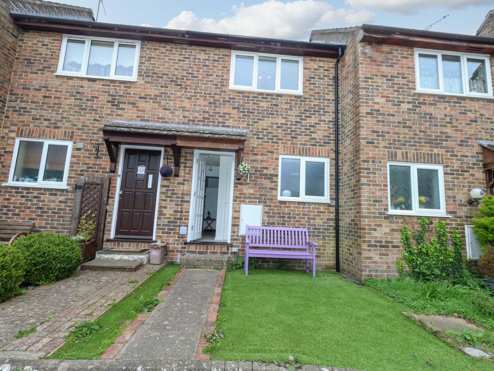 A front view of a house with a pathway and bench at Amber House in Dorchester