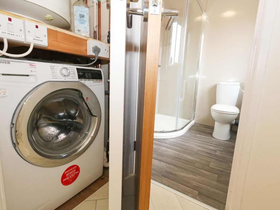 A bathroom with a washing machine and a toilet at Amber House in Dorchester