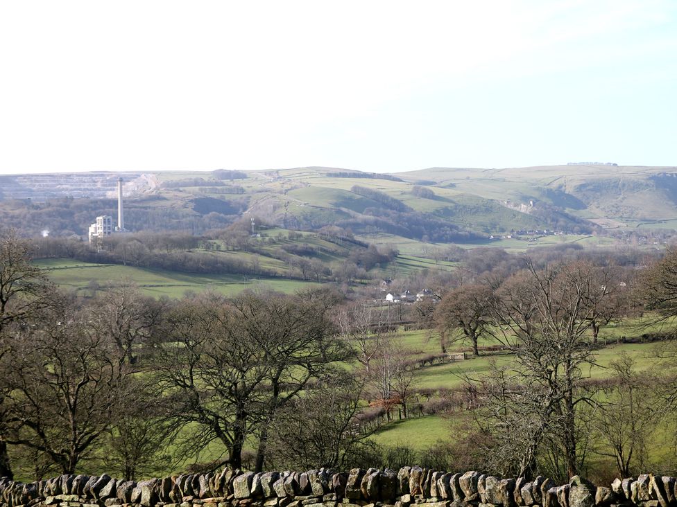 A hilly landscape with trees and stone wall at Thorn Tree Cottage Hope Valley