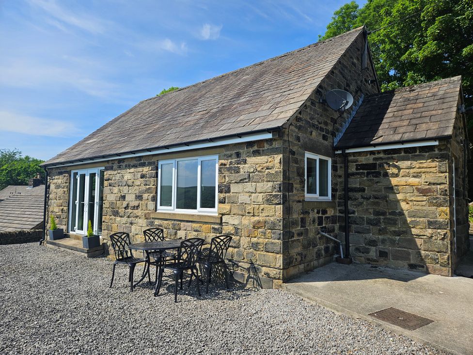A stone cottage with a table and chairs in the outdoor area at Thorn Tree Cottage Aston near Hope