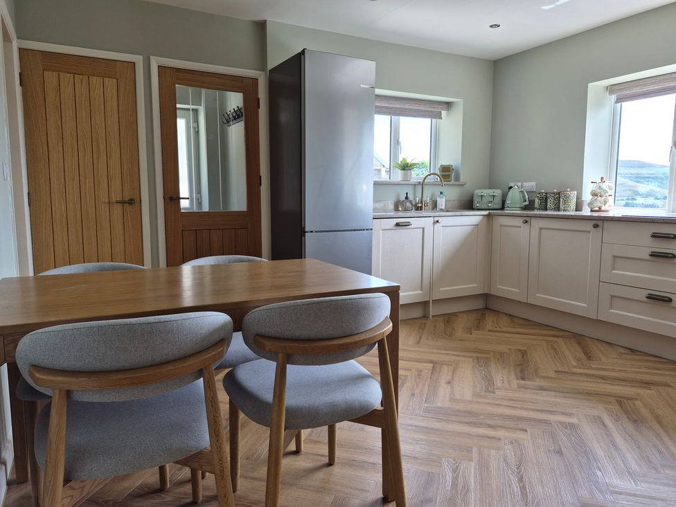 A kitchen with dining table and refrigerator at Thorn Tree Cottage Aston near Hope