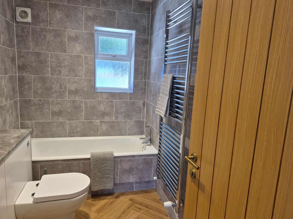 A bathroom with a bathtub and toilet at Thorn Tree Cottage Aston near Hope