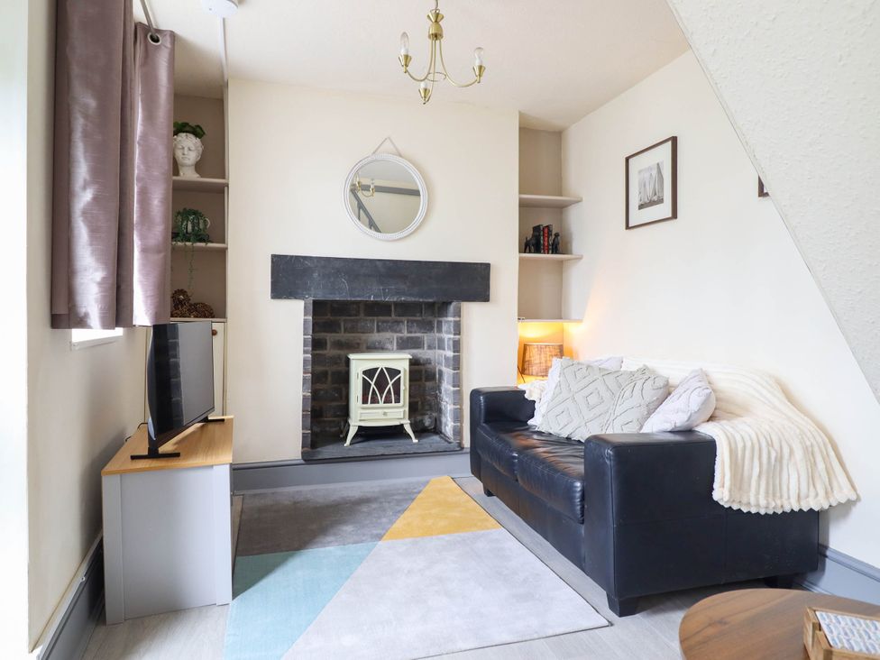 A living room with a sofa and TV at Harbour Cottage Barmouth