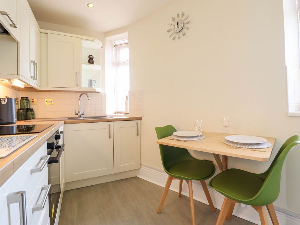 A kitchen with a table and chairs at Harbour Cottage in Barmouth