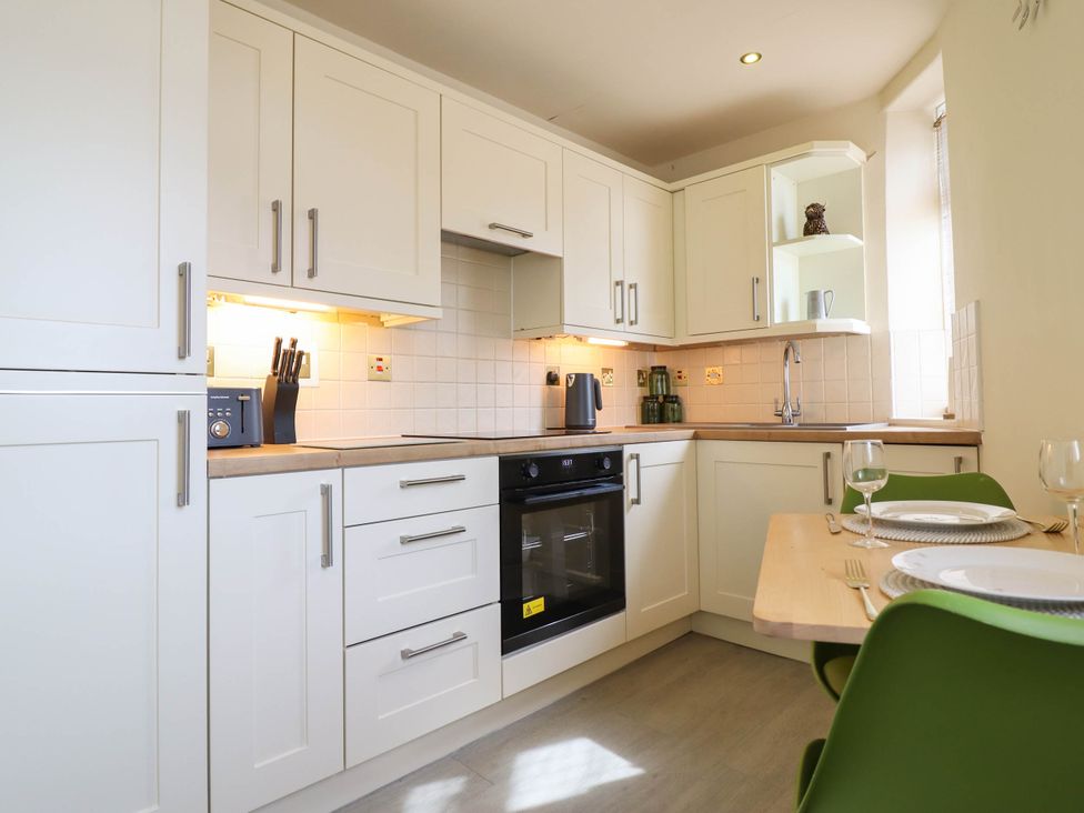 A kitchen with cabinets and appliances at Harbour Cottage in Barmouth