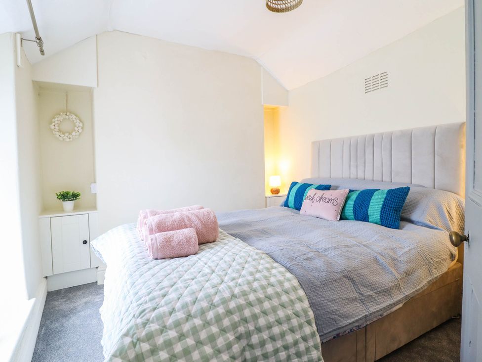 A bedroom with a bed and bedside table at Harbour Cottage in Barmouth