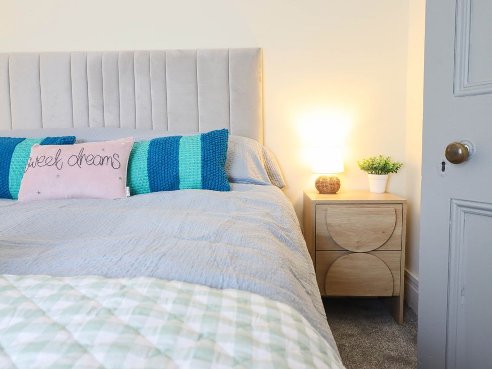 A bedroom with a bed and nightstand at Harbour Cottage Barmouth