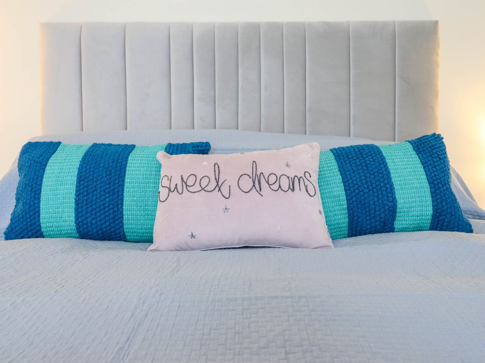 A bed with decorative pillows at Harbour Cottage in Barmouth