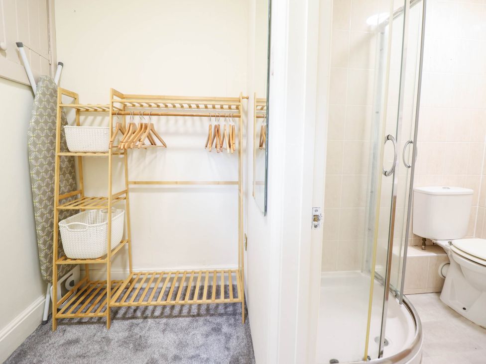 A bathroom with a clothes rack and shower at Harbour Cottage in Barmouth