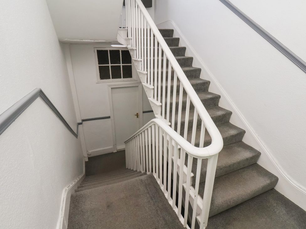 A staircase with a handrail and a door at Time Out in Whitby