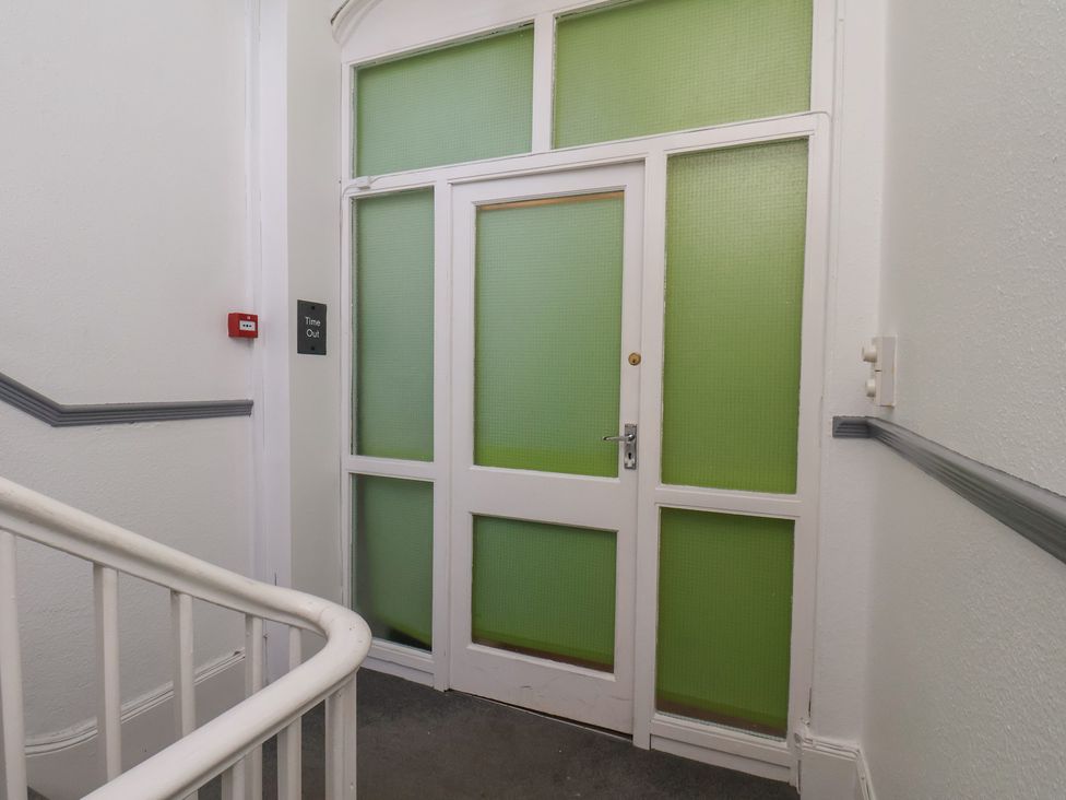 A door with a sign and staircase at Time Out in Whitby