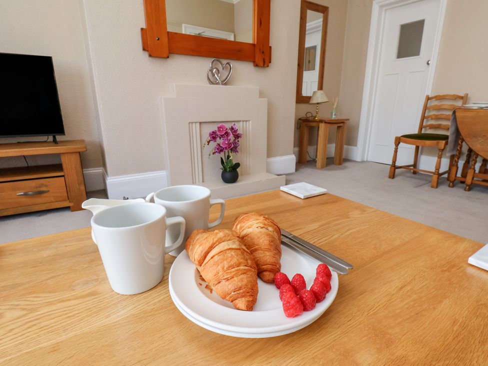 A living room with coffee cups and croissants on a table at Time Out in Whitby