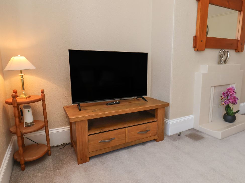 A living room with a television and a lamp at Time Out in Whitby