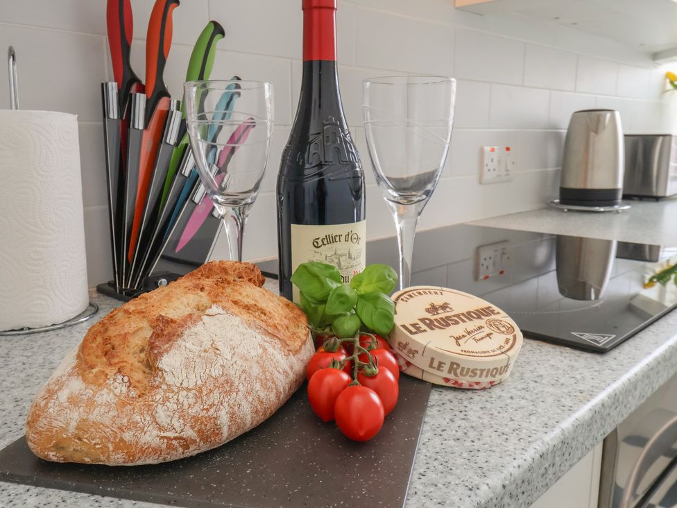 A kitchen countertop with wine, bread, tomatoes, and glasses at Time Out in Whitby