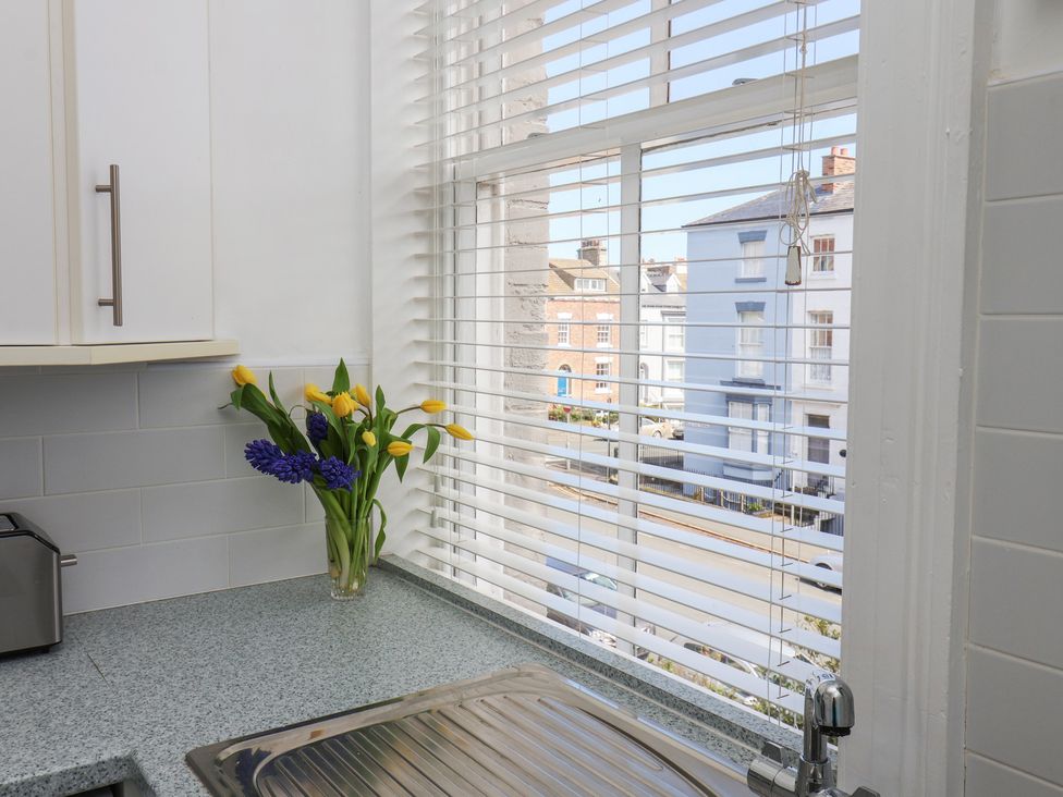 A kitchen with a sink and a window featuring flowers at Time Out in Whitby
