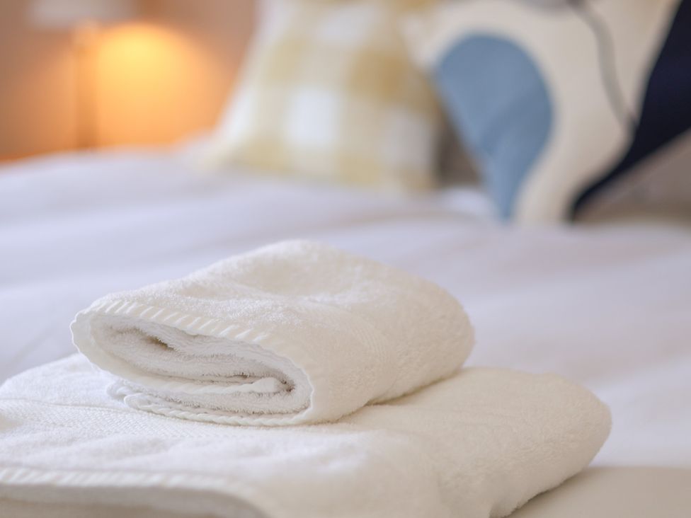 A stack of towels on a bed at Time Out in Whitby