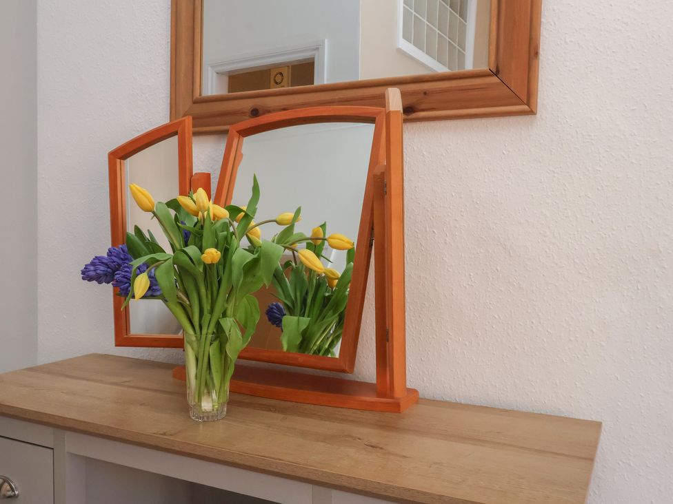 A mirror with flowers on a table at Time Out in Whitby