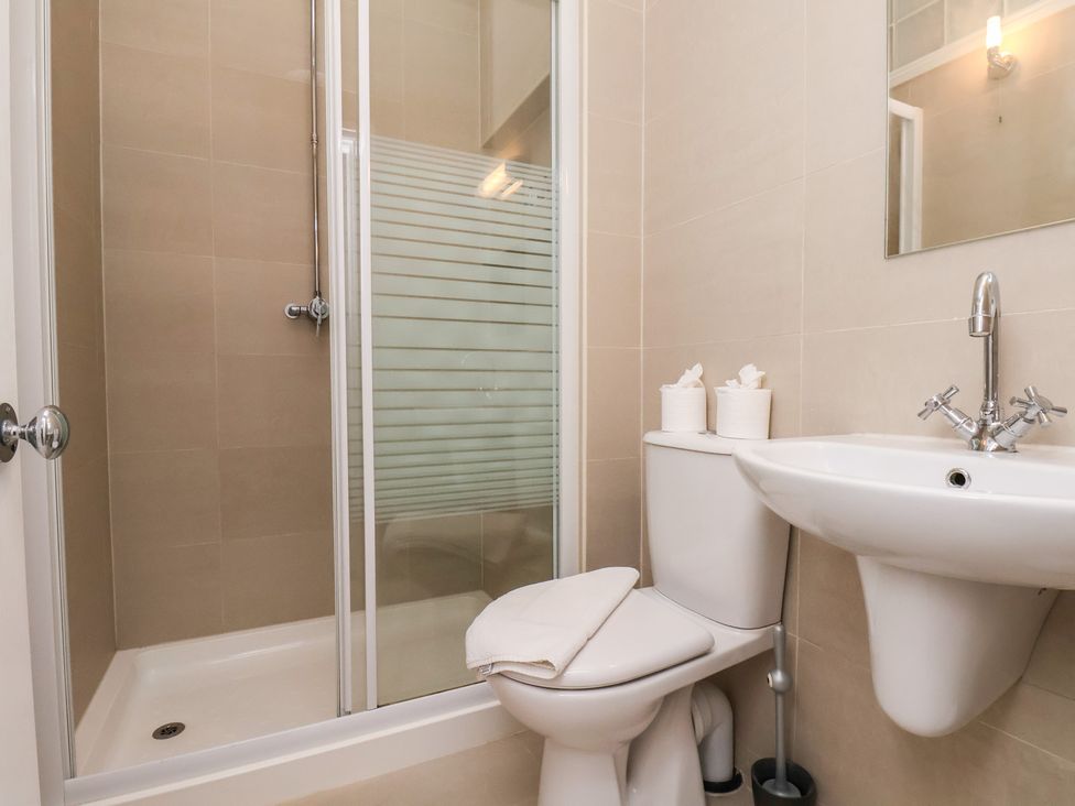 A bathroom with a shower, toilet, and sink at Time Out in Whitby