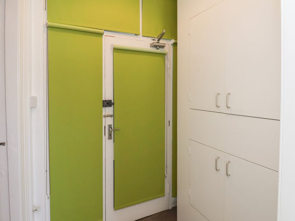 A hallway with a green wall and storage cabinets at Time Out Whitby