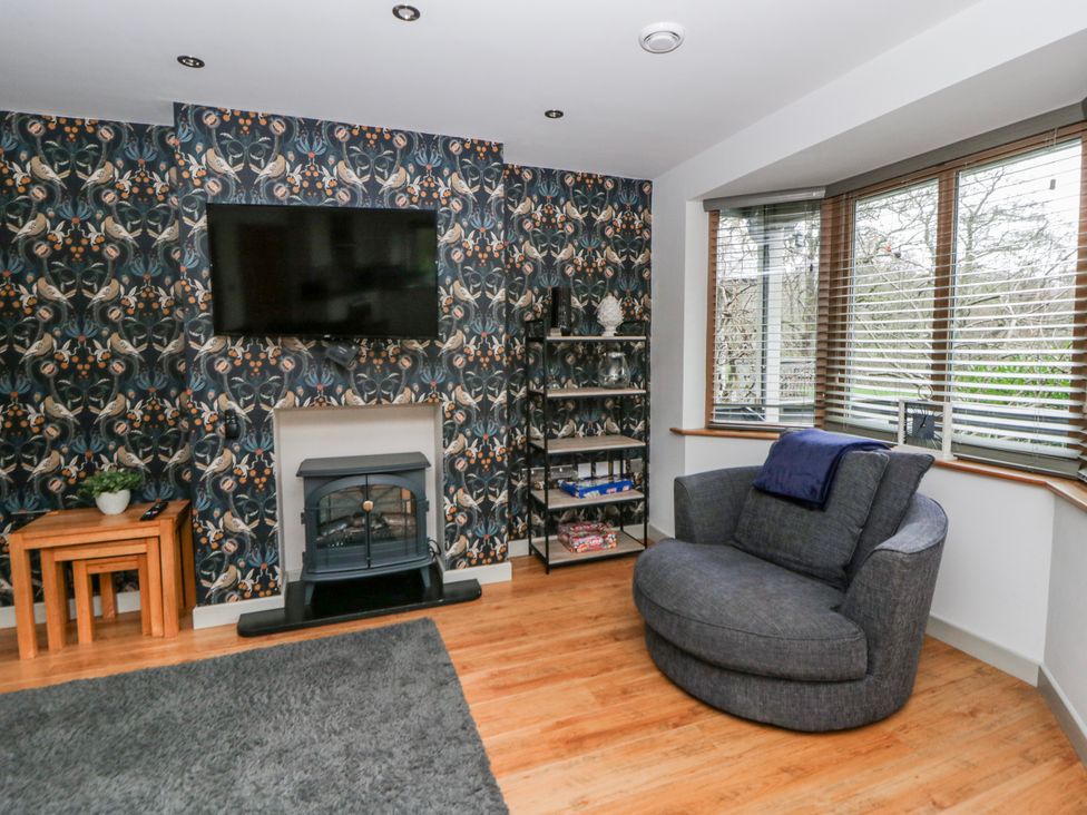 A living room with a television and fireplace at Maple Lodge in Knighton