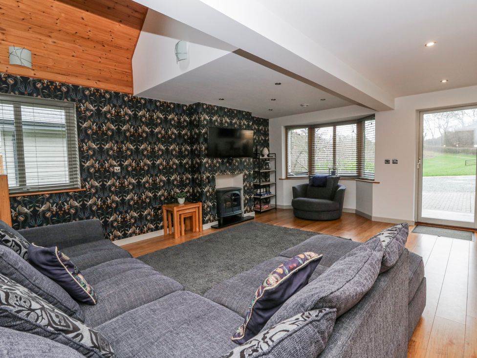 A living room with a television and sofa at Maple Lodge Knighton