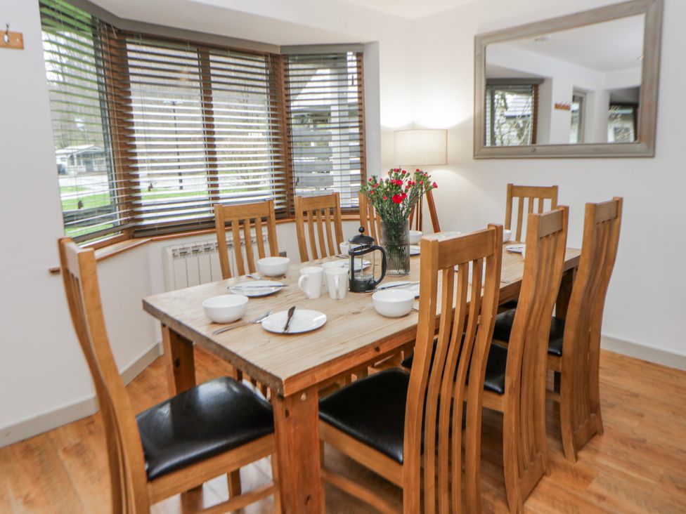 A dining room with a table and chairs at Maple Lodge in Knighton