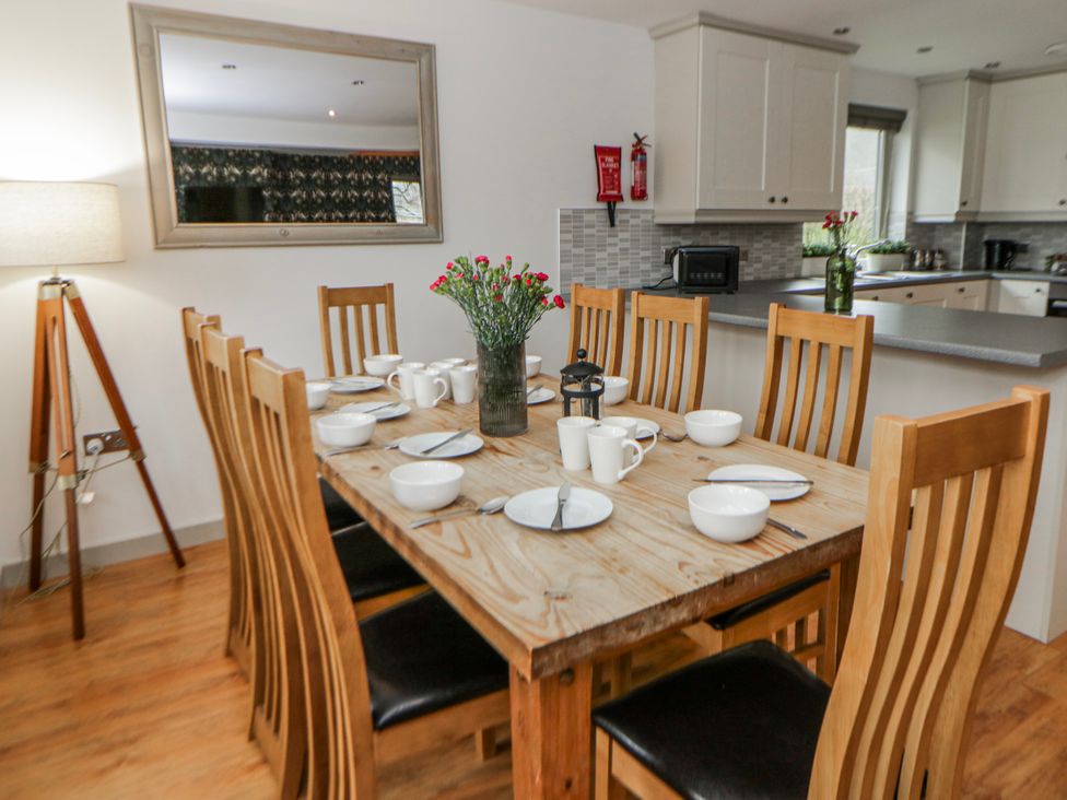 A dining room with a wooden table and chairs at Maple Lodge in Knighton