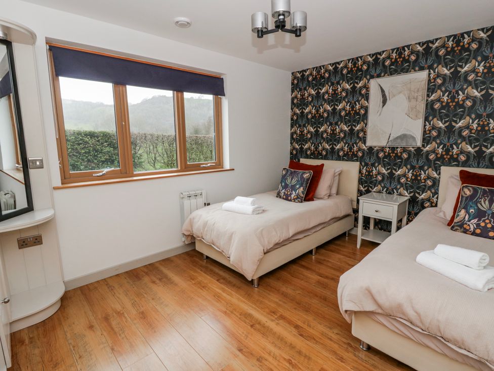 A bedroom with two beds and a window at Maple Lodge in Knighton