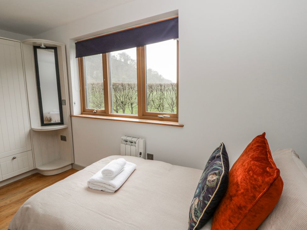 A bedroom with a bed and towels on top at Maple Lodge in Knighton