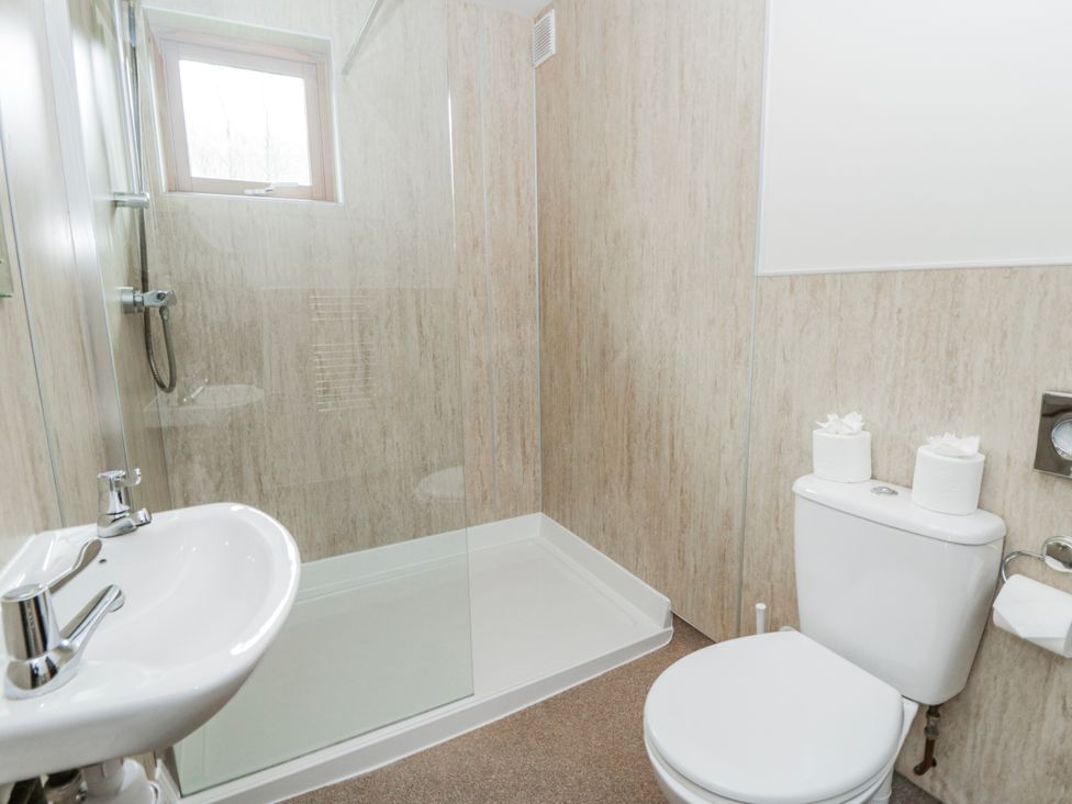 A bathroom with a shower, sink and toilet at Maple Lodge in Knighton