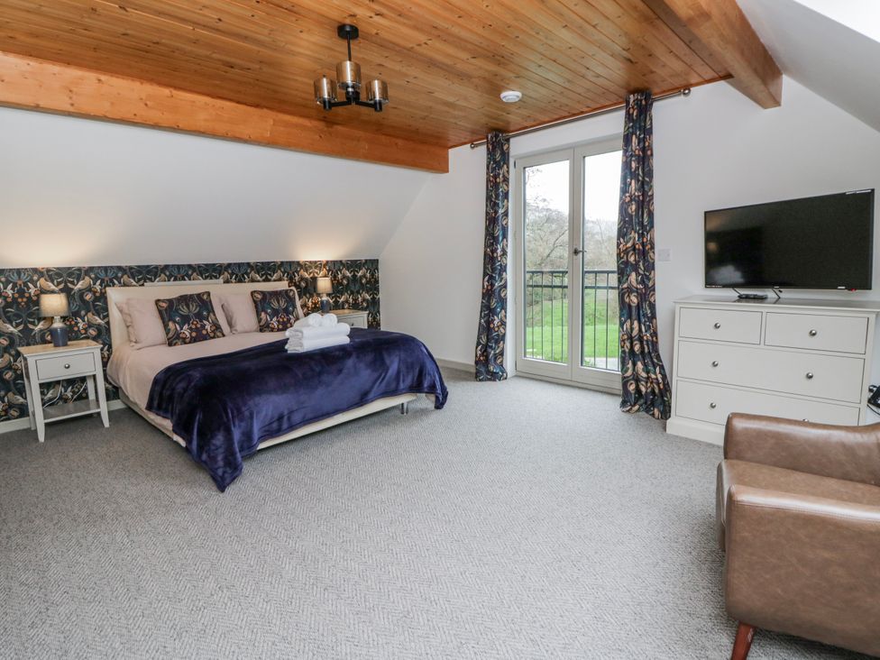 A bedroom with a bed and television at Maple Lodge in Knighton
