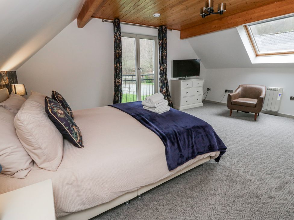 A bedroom with a bed, dresser, and tv at Maple Lodge in Knighton