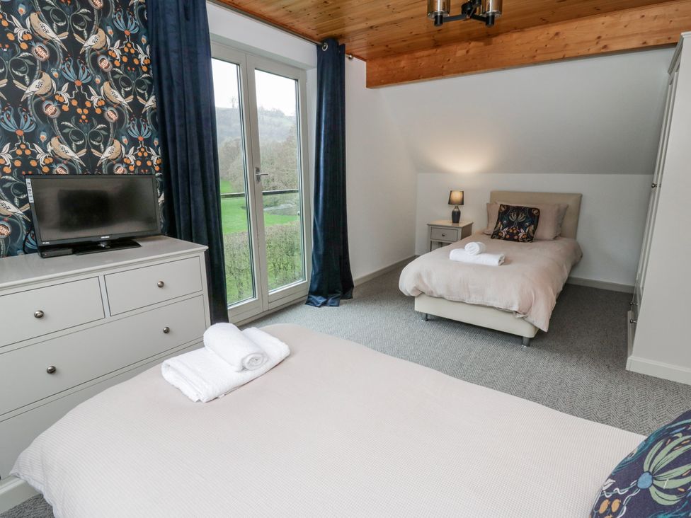 A bedroom with a bed and a television at Maple Lodge in Knighton