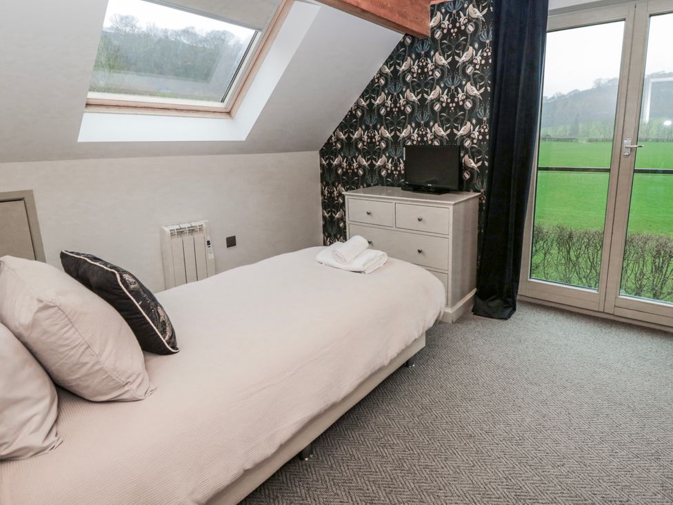 A bedroom with a bed and dresser at Maple Lodge in Knighton