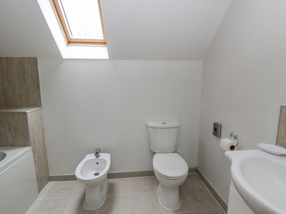 A bathroom with a toilet, bidet, and sink at Maple Lodge in Knighton