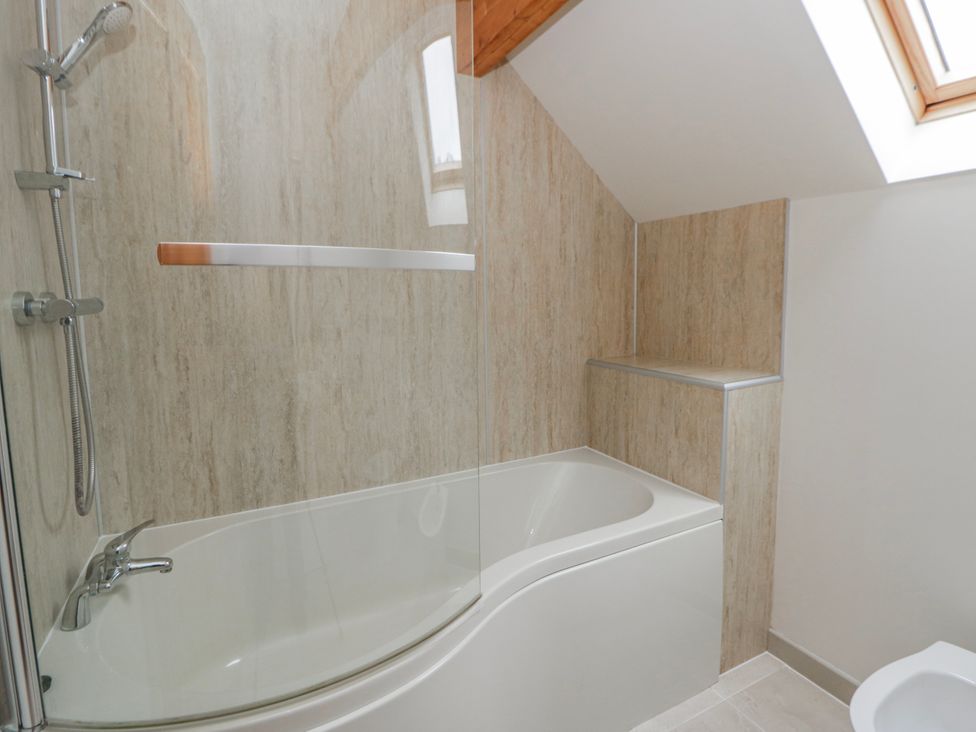 A bathroom with a bathtub and shower installed at Maple Lodge Knighton