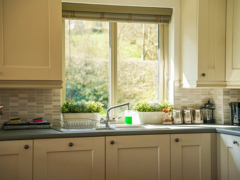 A kitchen with sink and window at Maple Lodge in Llangunllo