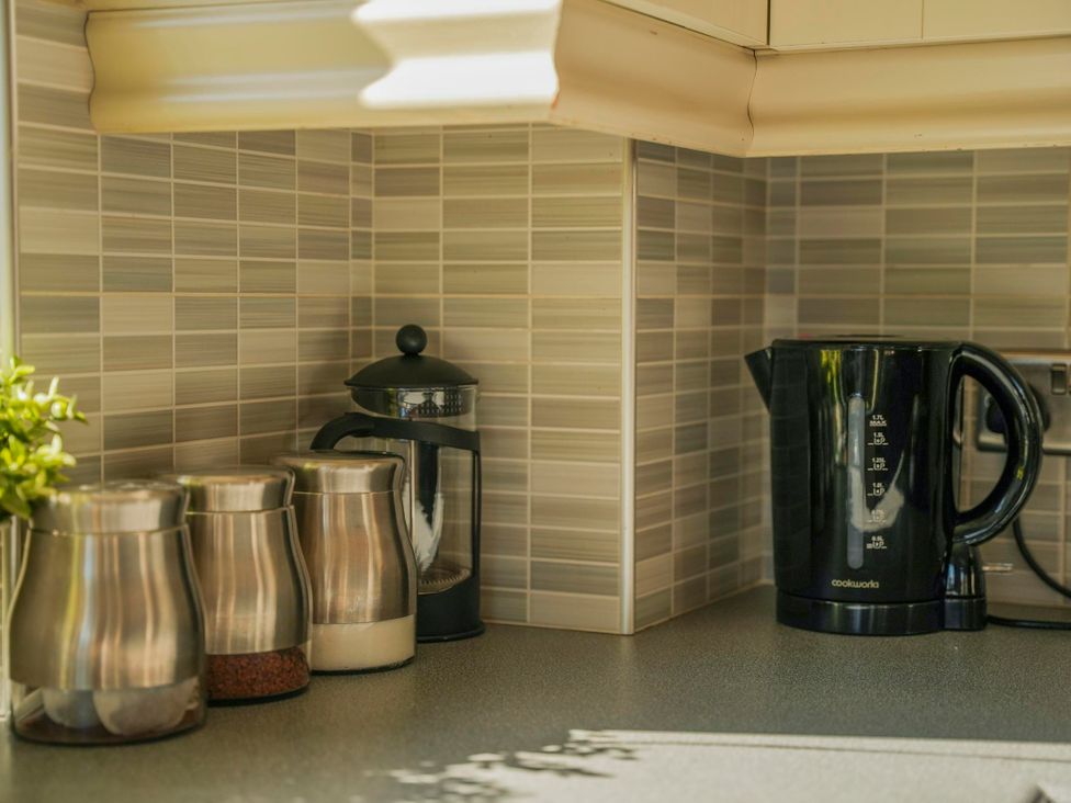 A kitchen counter with a kettle and coffee maker at Maple Lodge Llangunllo