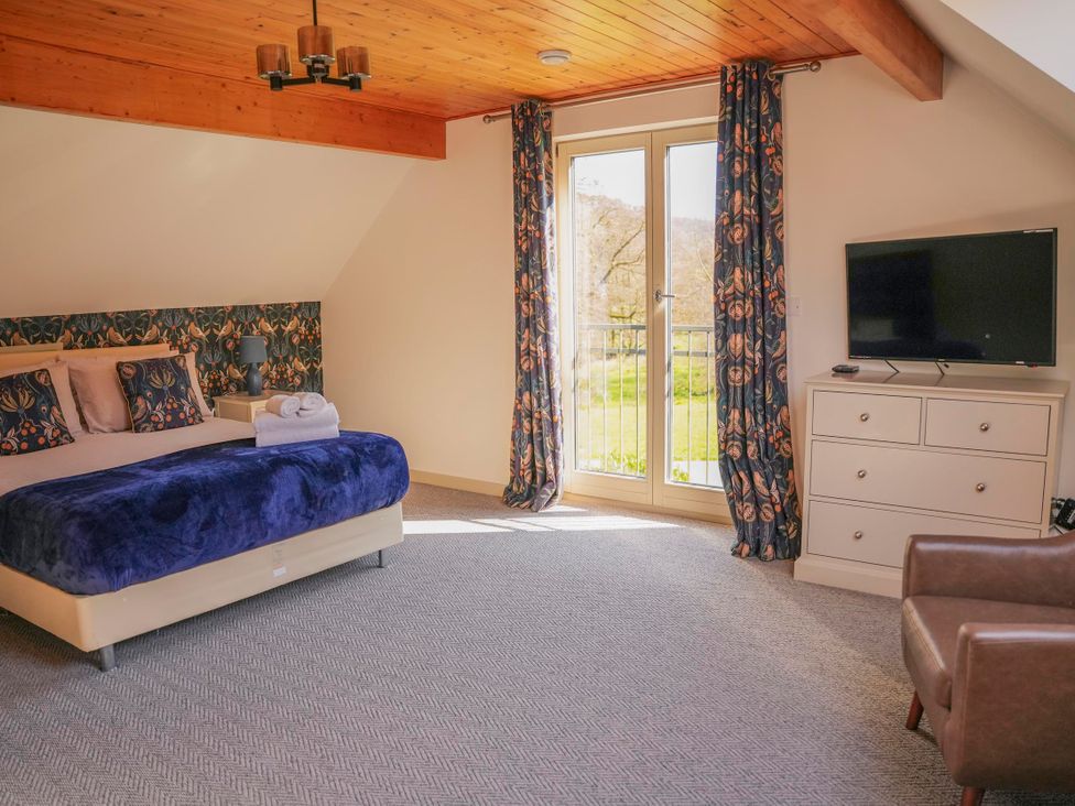 A bedroom with a bed and television at Maple Lodge in Llangunllo