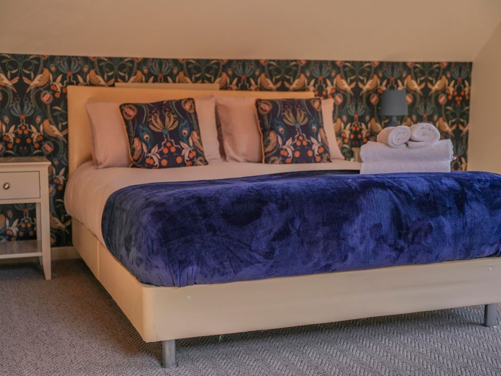 A bedroom with a bed and pillows at Maple Lodge in Llangunllo