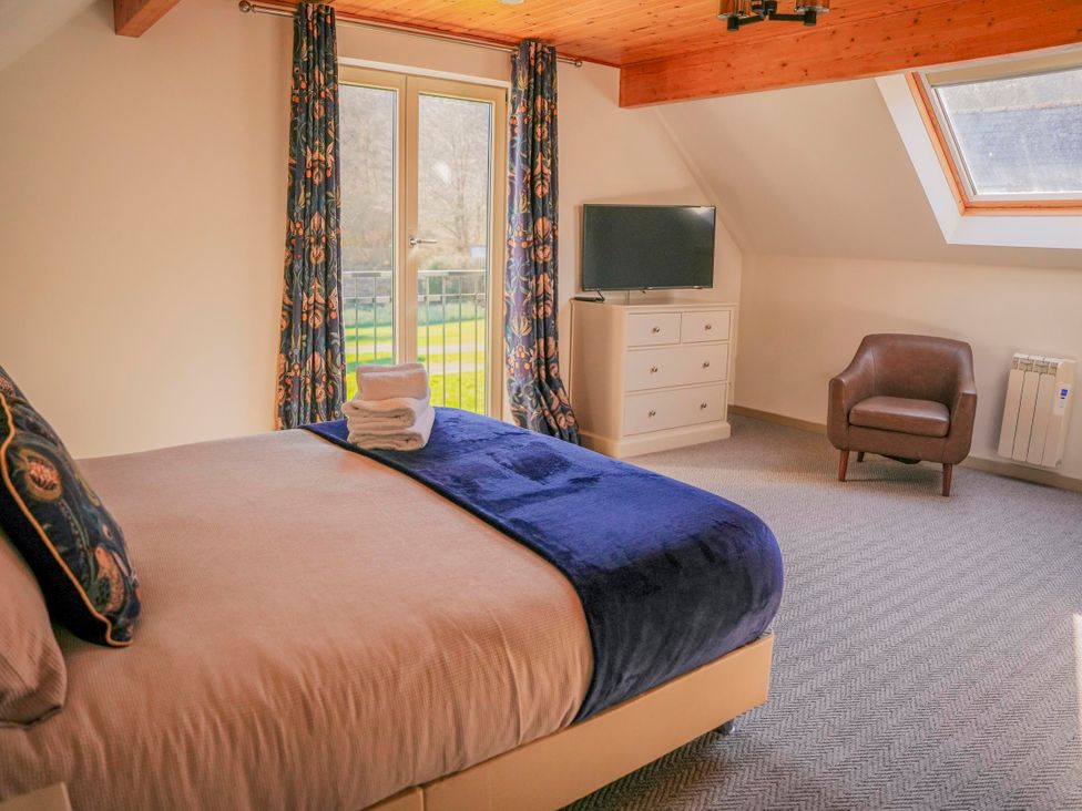 A bedroom with a bed and a television at Maple Lodge Llangunllo
