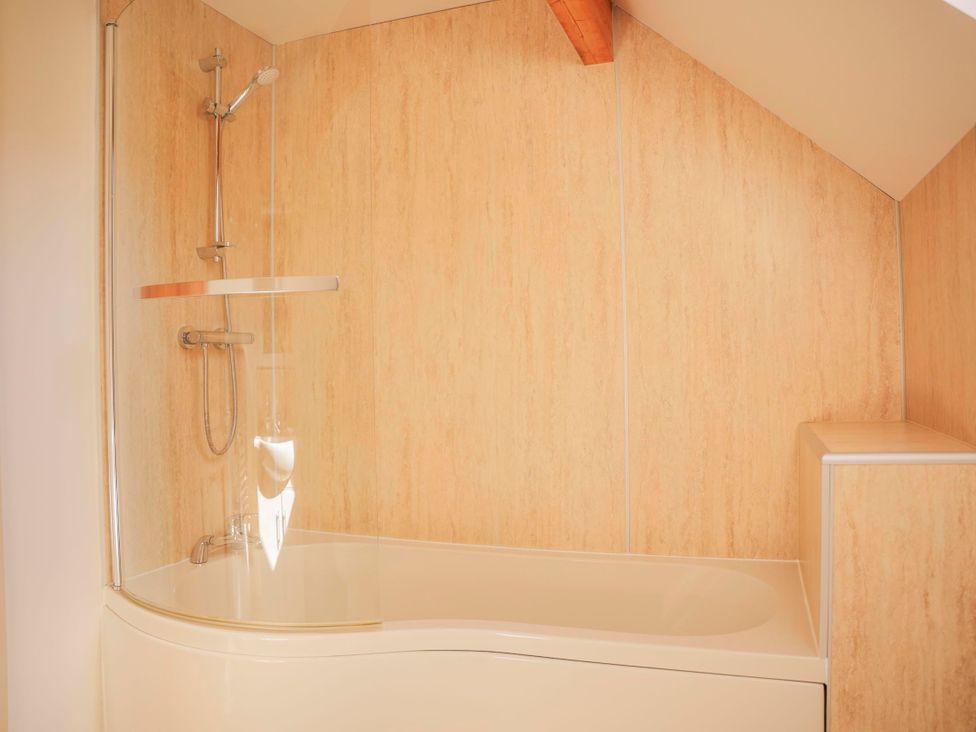 A bathroom with a bathtub and shower at Maple Lodge Llangunllo
