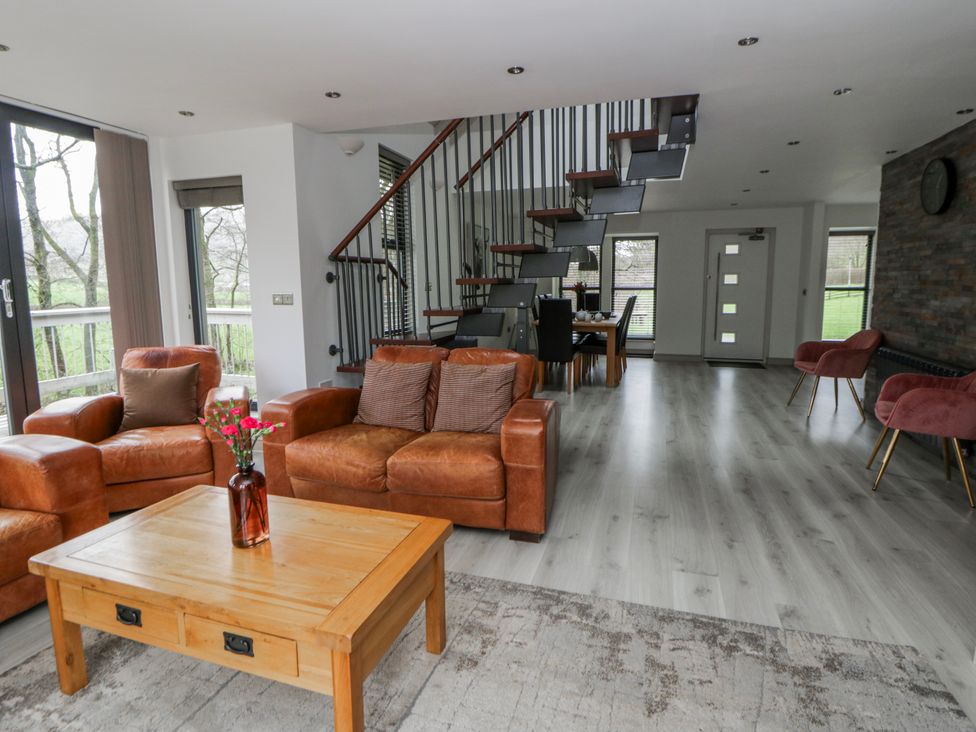 A living room with a sofa and wooden table at Oak Lodge in Knighton