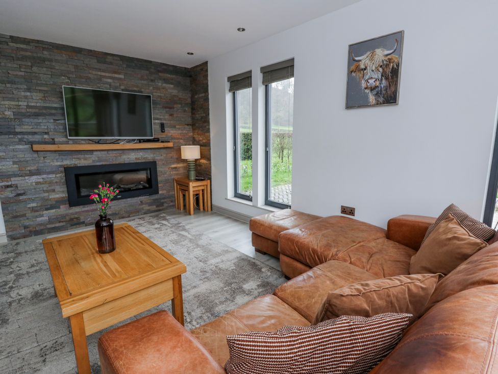 A living room with a television and a sofa at Oak Lodge Knighton